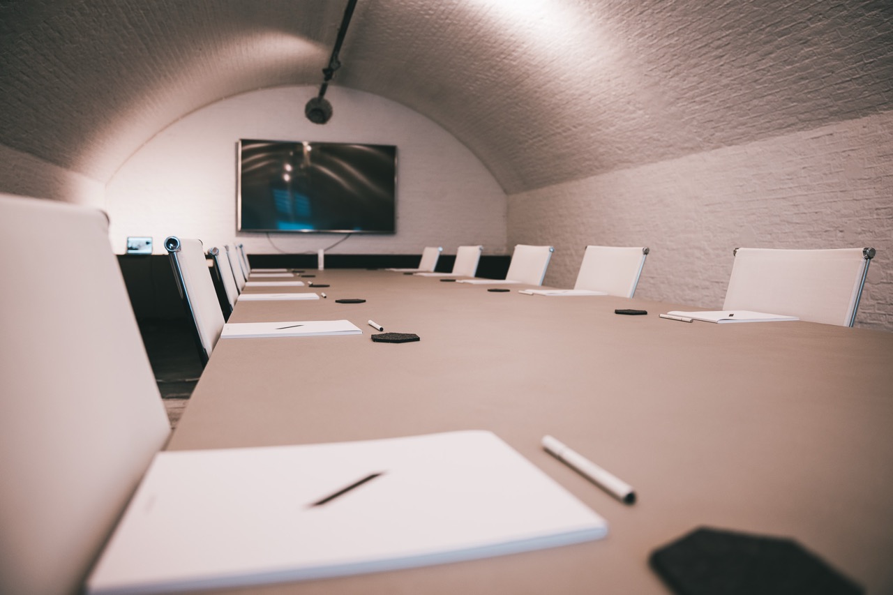Opgeruimde lichte vergaderruimte in gerestaureerde bunker.